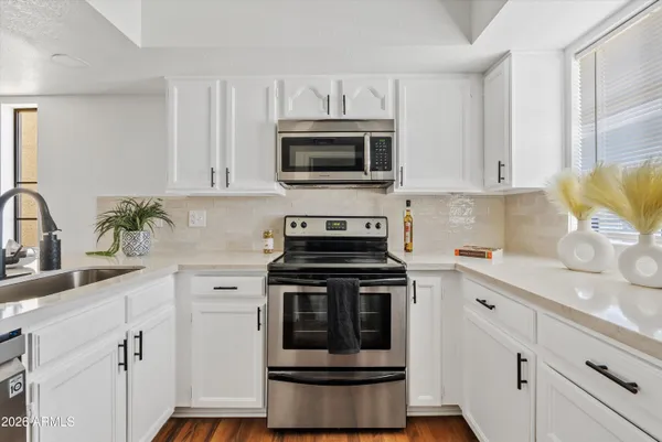 a kitchen with stainless steel appliances a sink a stove and cabinets