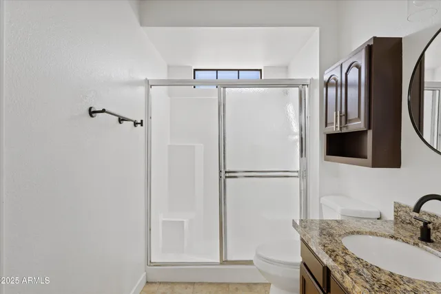 a bathroom with a granite countertop shower sink and mirror