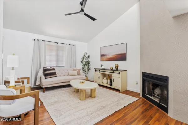 a living room with furniture a wooden floor and a potted plant