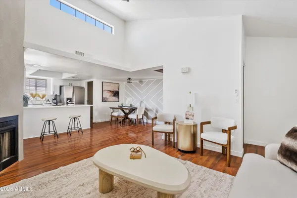 a living room with stainless steel appliances kitchen island granite countertop furniture and a wooden floor