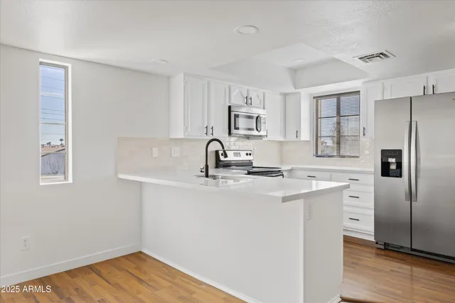 a kitchen with stainless steel appliances a sink stove and refrigerator