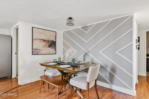 a dining room with stainless steel appliances kitchen island a table chairs in it and white cabinets