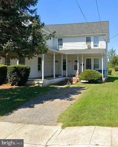 a front view of a house with a yard and potted plants
