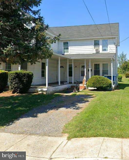 a front view of a house with a yard and potted plants