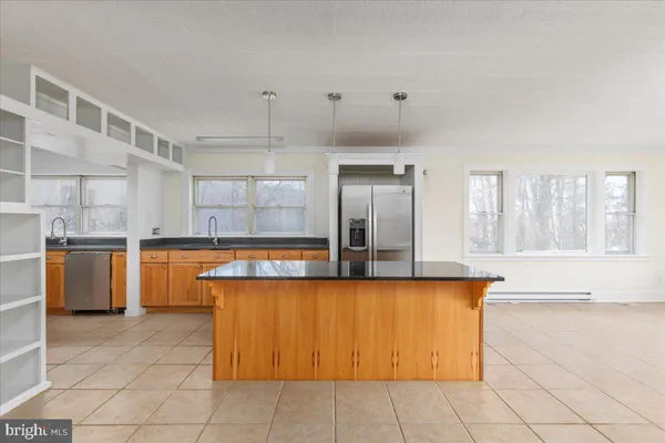 a large kitchen with granite countertop a large counter top and appliances