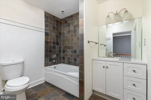 a bathroom with a bathtub shower sink and toilet
