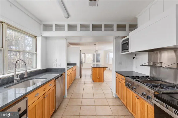 a kitchen with stainless steel appliances granite countertop a sink and a stove
