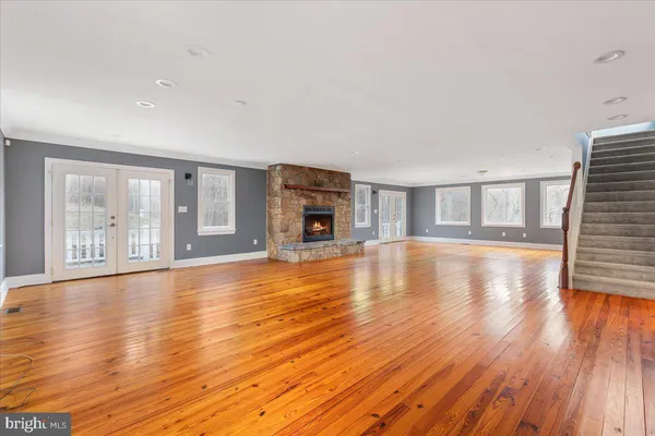 a view of empty room with wooden floor and fireplace