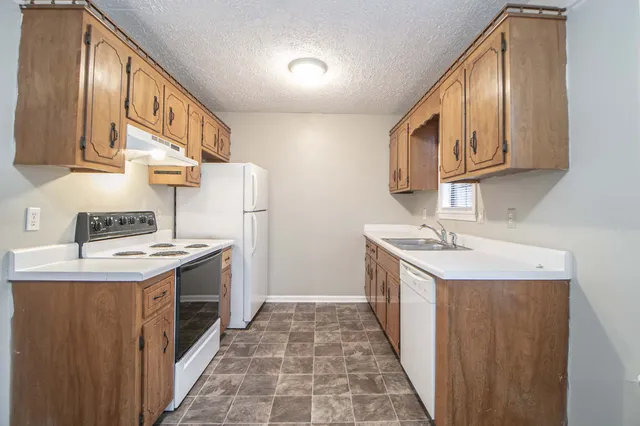 a kitchen with a sink stove top oven and cabinets