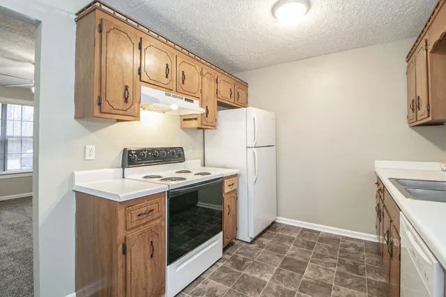 a kitchen with a stove top oven and cabinets