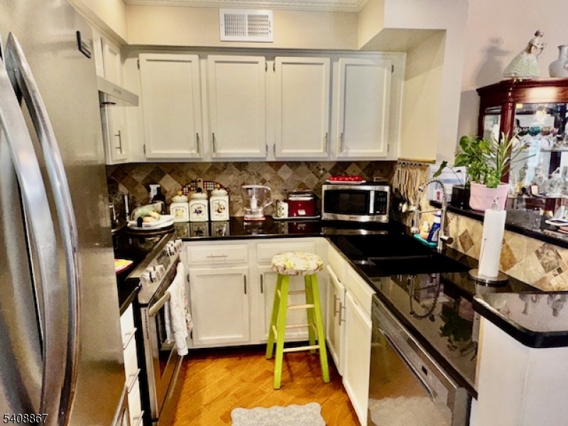 13 Ridgeview Terrace Oak Ridge, NJ 07438 - Photo 6 of 22 a kitchen with stainless steel appliances granite countertop a refrigerator a stove and white cabinets