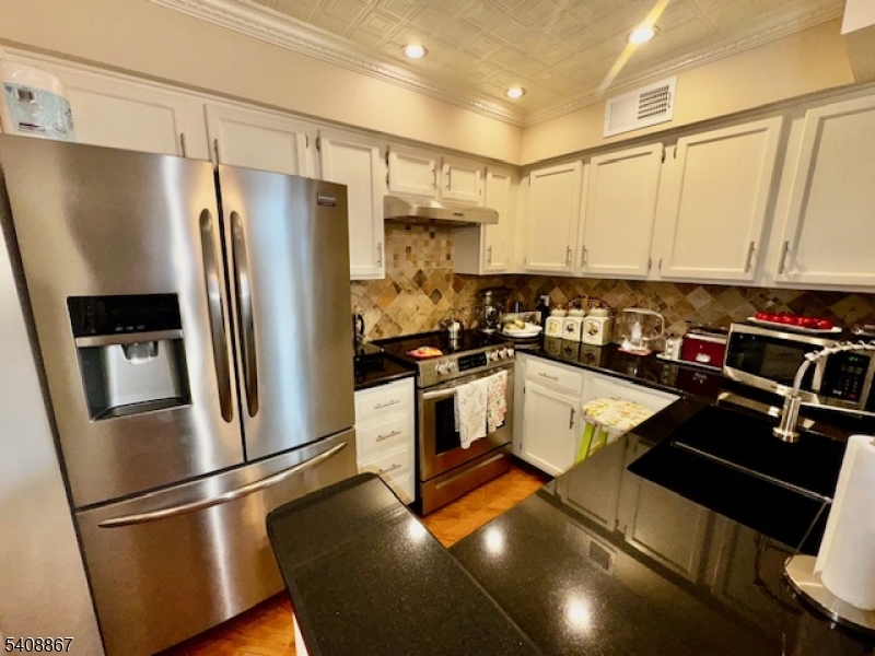 13 Ridgeview Terrace Oak Ridge, NJ 07438 - Photo 7 of 22 a kitchen with a refrigerator a sink and cabinets