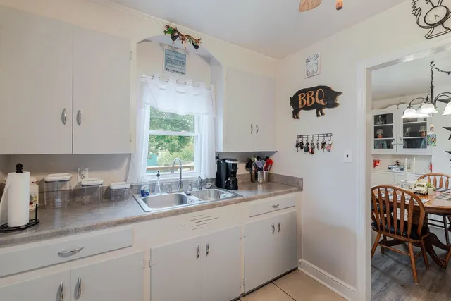 a bench is sitting in front of house with wooden fence