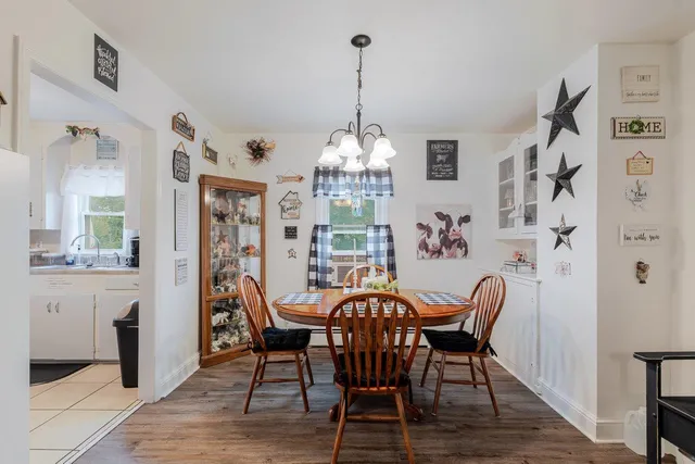 a view of a roof deck with table and chairs a barbeque with wooden floor and fence