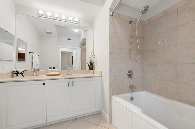 a bathroom with a tub a sink and mirror