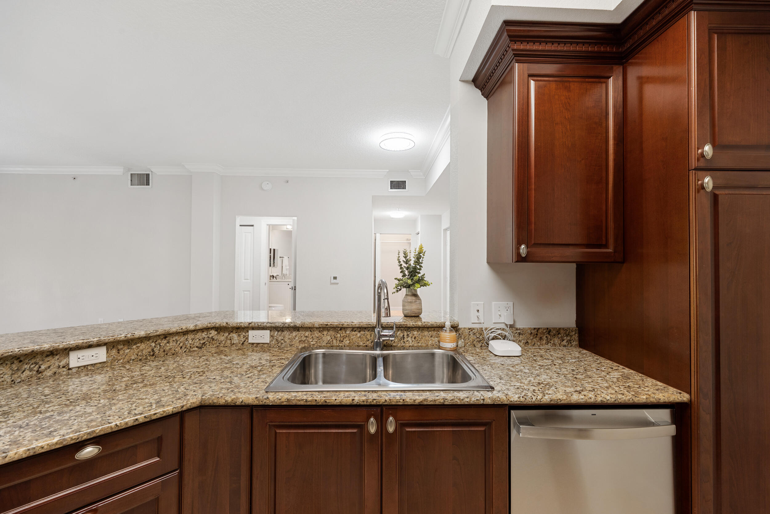 1690 Renaissance Commons Boulevard, Unit 1312 Boynton Beach, FL 33426 - Photo 3 of 39 a kitchen with granite countertop a sink and cabinets