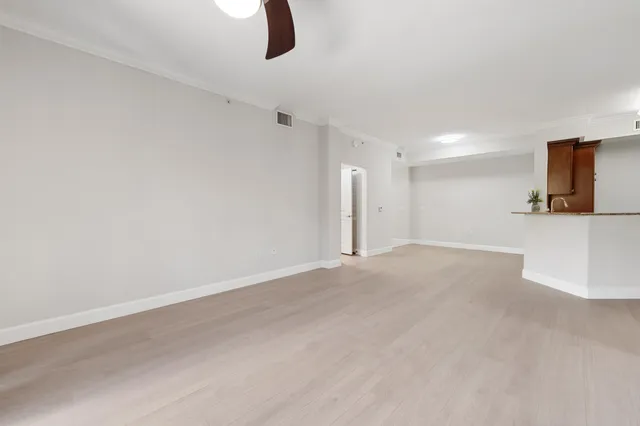 a view of a room with a ceiling fan and window