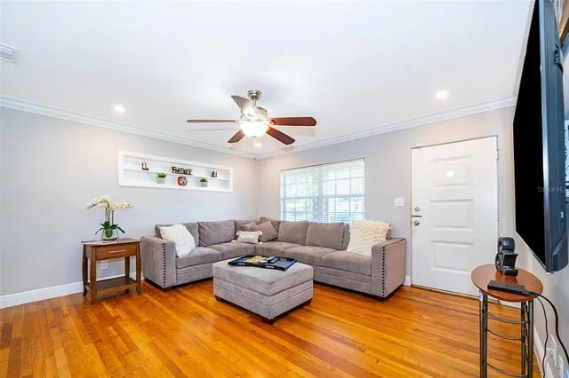 a living room with furniture flat screen tv and a large window