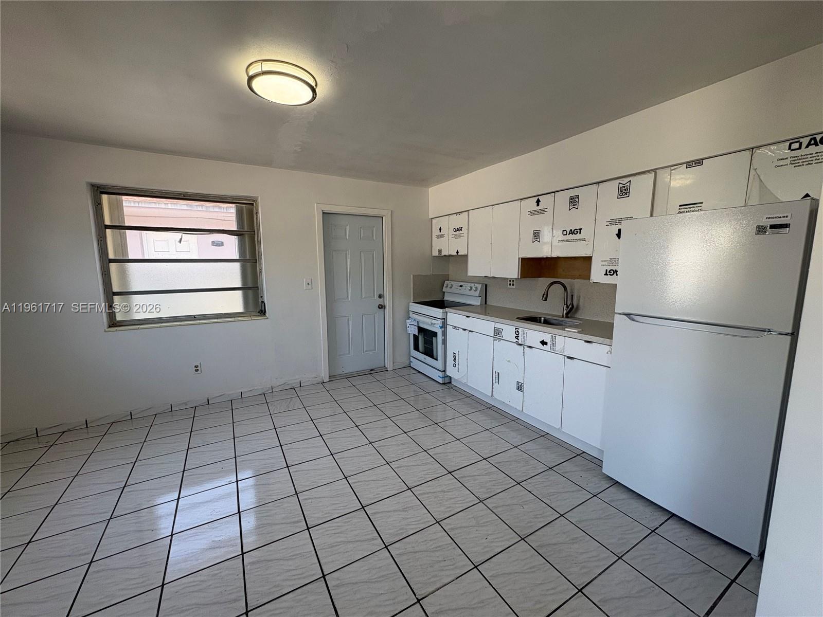 2752 Southwest 25th Terrace, Unit A Miami, FL 33133 - Photo 3 of 7 a kitchen with stainless steel appliances a refrigerator sink and cabinets