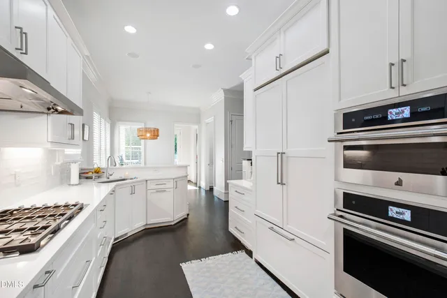 a open kitchen with stainless steel appliances kitchen island granite countertop a table chairs sink and cabinets