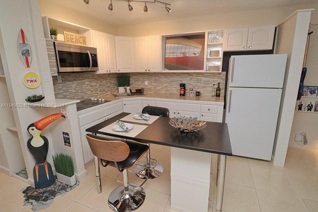 1801 South Surf Road, Unit 2E Hollywood, FL 33019 - Photo 8 of 24 a kitchen with stainless steel appliances a refrigerator sink and cabinets