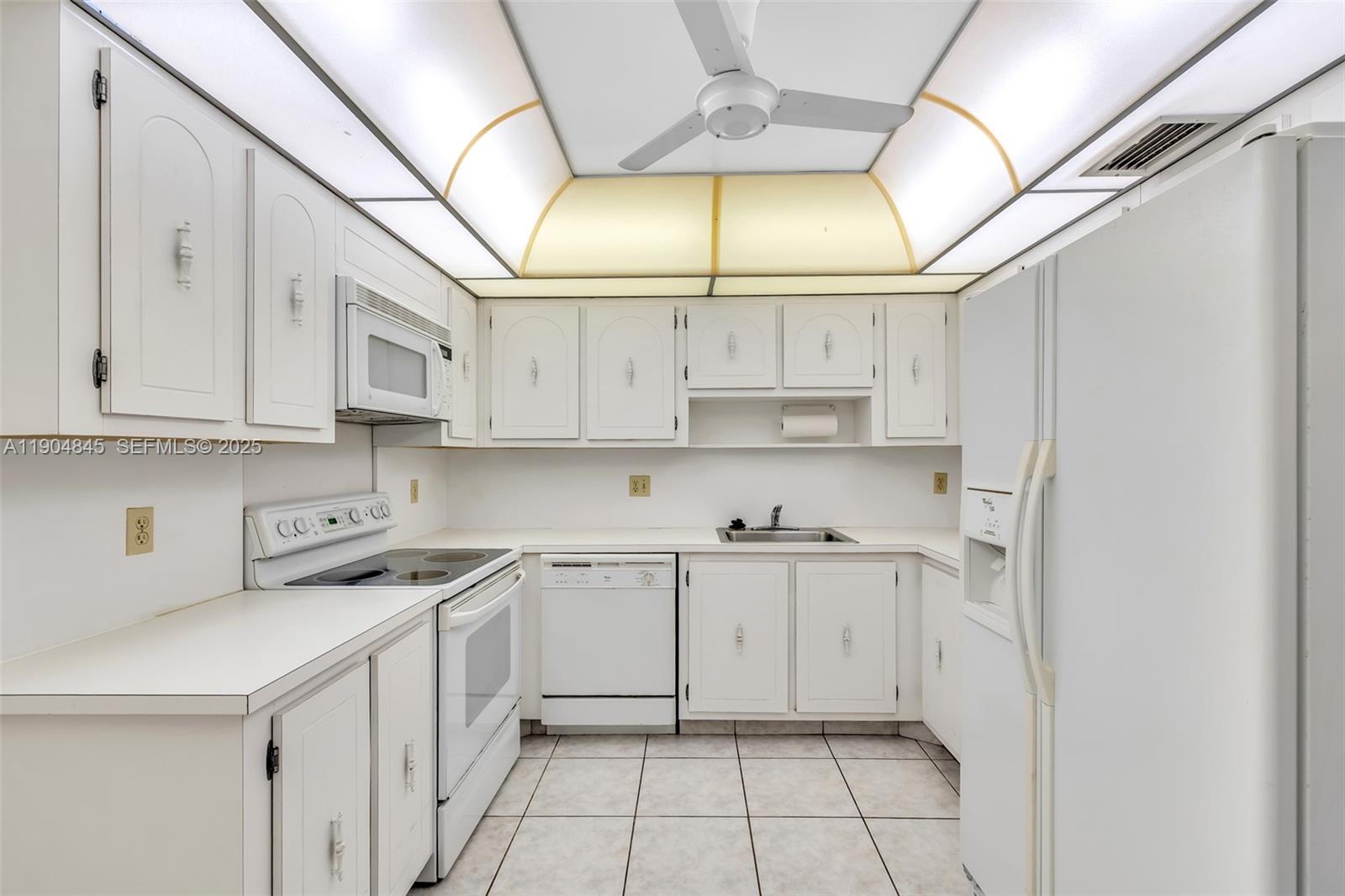 16300 Golf Club Road, Unit 408 Weston, FL 33326 - Photo 20 of 31 a kitchen with stainless steel appliances white cabinets and a sink