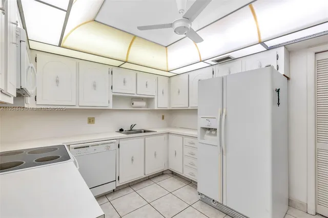 a kitchen with white cabinets and white appliances