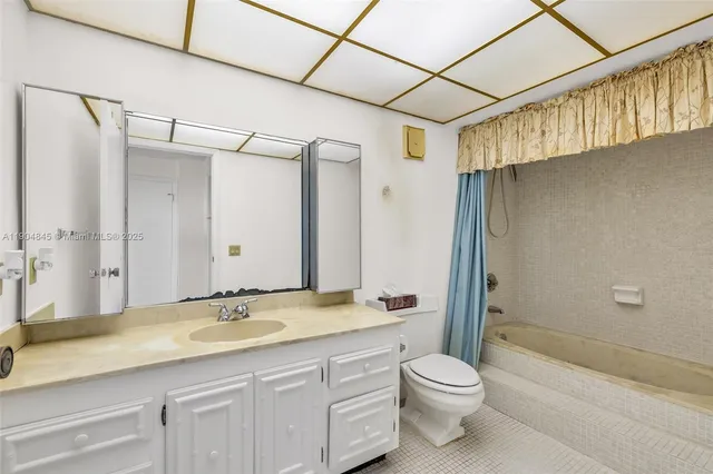 a bathroom with a granite countertop sink a toilet and shower