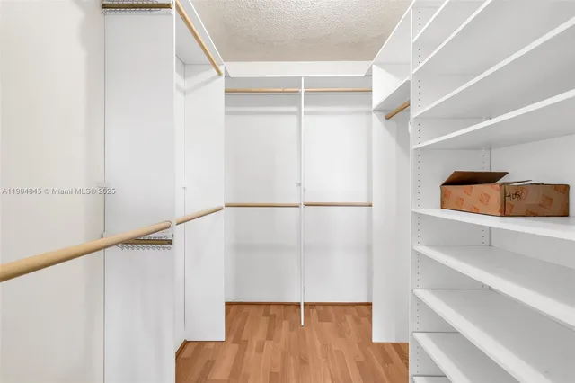 a view of walk in closet with empty racks