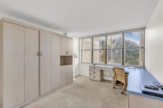 a view of a livingroom with workspace and a window