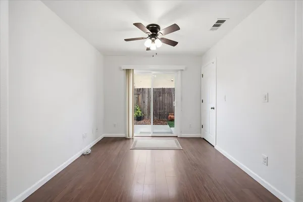 an empty room with wooden floor and windows