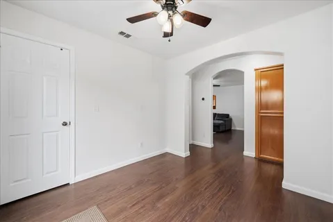 a view of an empty room with wooden floor