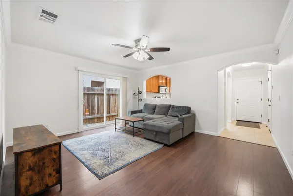 a living room with furniture and a wooden floor