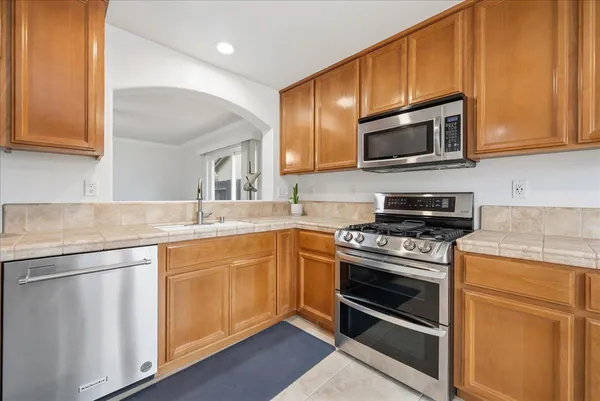 a kitchen with stainless steel appliances granite countertop a stove microwave and sink