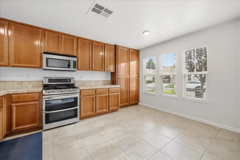 a kitchen with stainless steel appliances granite countertop a stove microwave and a sink