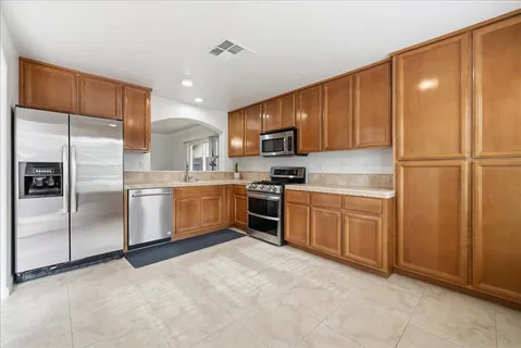 a kitchen with stainless steel appliances granite countertop a refrigerator sink and microwave