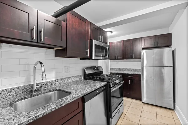 a kitchen with kitchen island granite countertop a sink stove and refrigerator