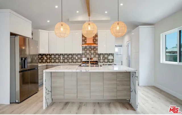 a large kitchen with granite countertop a sink cabinets and stainless steel appliances