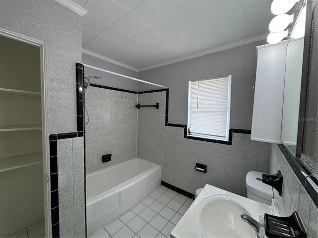 a bathroom with a sink a toilet a mirror and shower