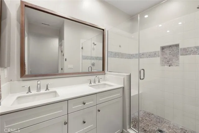 a bathroom with double sink and a mirror