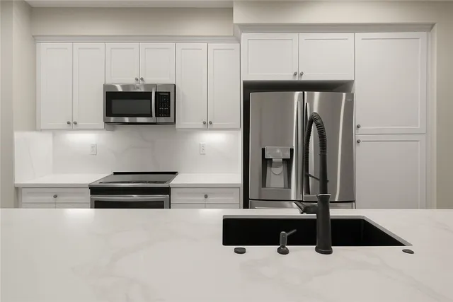 a kitchen with stainless steel appliances a refrigerator and cabinets