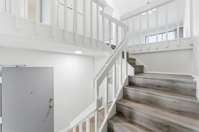 a view of staircase with lots of frames on wall and cabinets