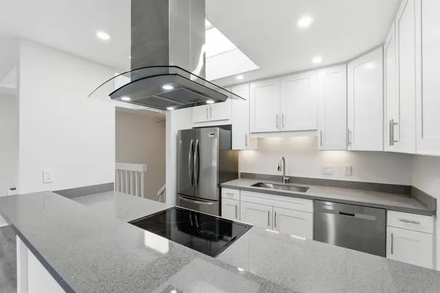 a kitchen with stainless steel appliances granite countertop a sink a stove and a refrigerator