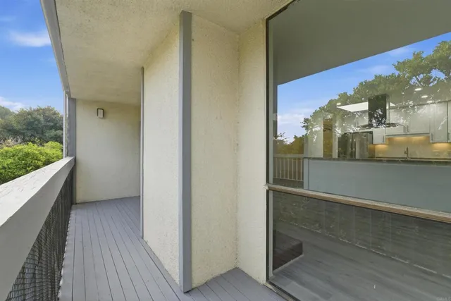 a view of a balcony with wooden floor and fence