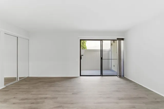 an empty room with sliding door and windows