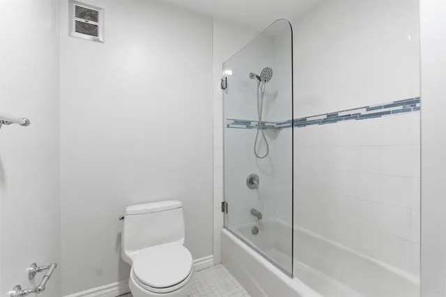 a white toilet sitting next to a bath tub