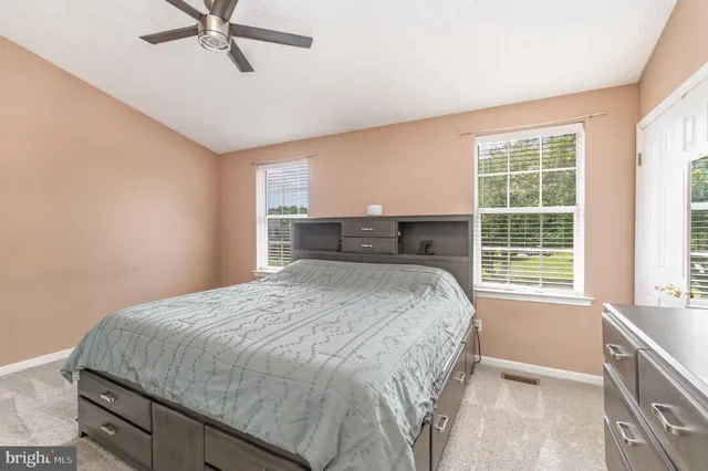 a bed sitting in a spacious bedroom next to a window