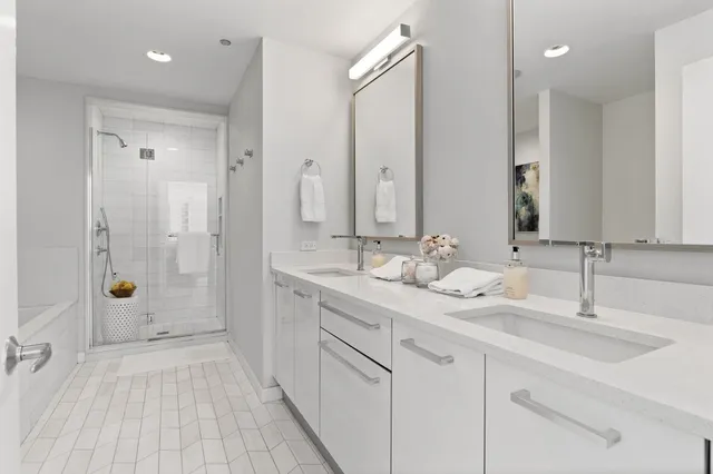 a bathroom with a double vanity sink and shower