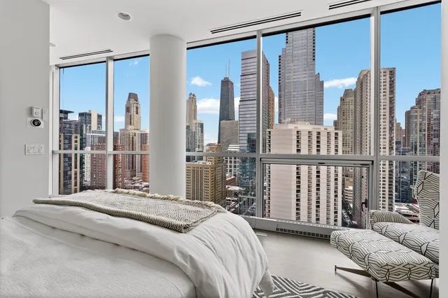 a bedroom with a large window and a bed