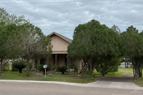 a front view of a house with a yard garage and trees